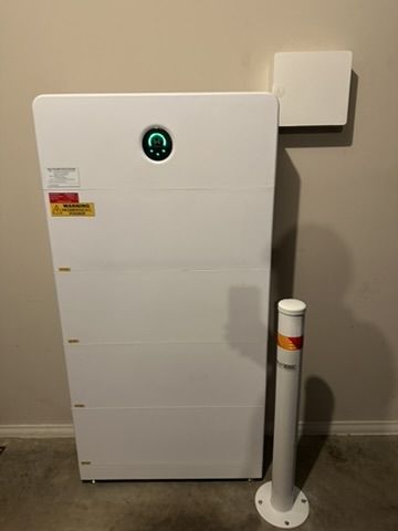 Home battery installed in a garage with bollard protection